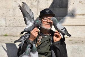 Pulski ljubitelj životinja hrani golubove na praznom Forumu
